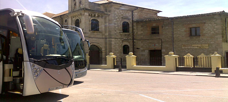 Dos autocares de Francisco Heras aparcados junto a una iglesia